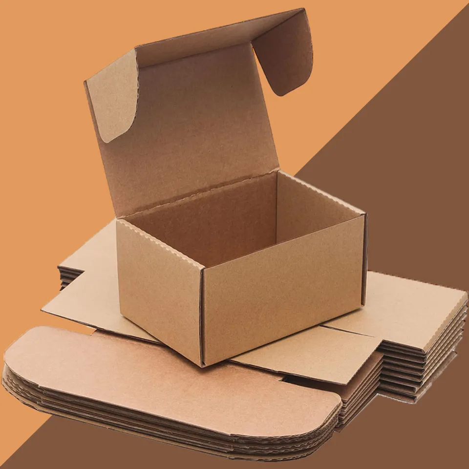 Folding Small Mailing Boxes: Small kraft mailing box standing open on a pile of flat creased blanks